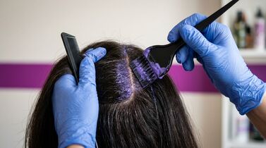 Aplicação de tintura de cabelo roxa em mulher.