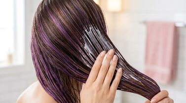 Aplicação de máscara capilar em cabelo roxo.
