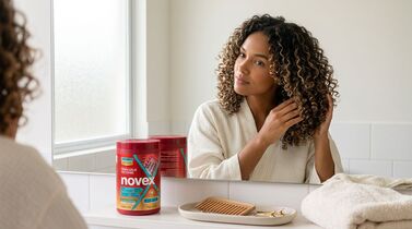 Mulher cuidando dos cabelos com produtos Novex.