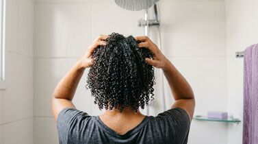 Pessoa lavando cabelo no chuveiro