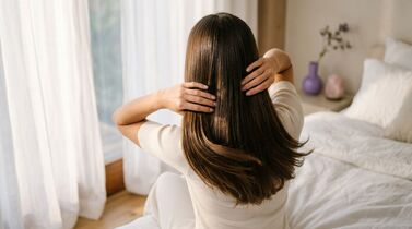 Mulher com cabelo longo estilizando-se em quarto claro