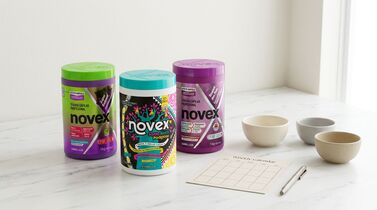 Três potes de produtos Novex em mesa de mármore