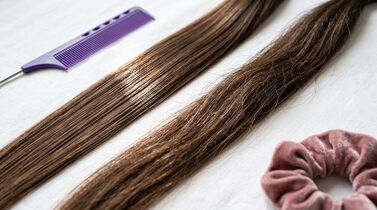 Cabelo liso com pente roxo e prendedor rosa.